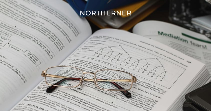 Jemand liest eine Studie und legt die Brille in das Buch