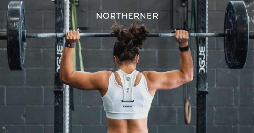 Eine Frau im Gym trainert mit Gewichten