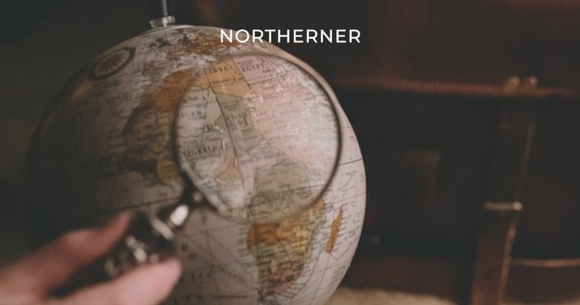 Eine Lupe zeigt auf eine Weltkugel