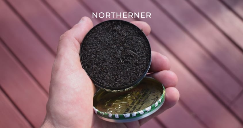 Jemand hält eine Dose mit losem Snus