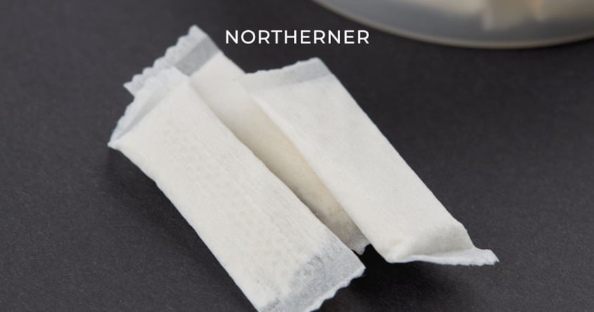 Drei Beutel All-White-Snus liegen auf einem Tisch