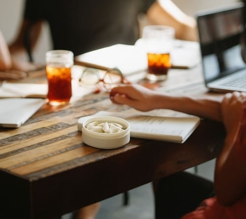 group of people sat at table with nicotine pouch can, for world snus day