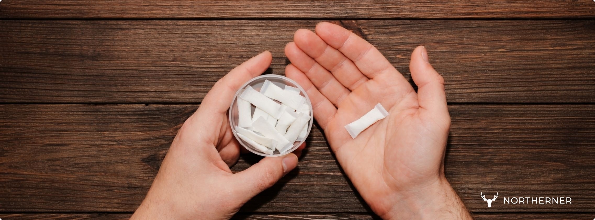 Outstretched hands holding a nicotine pouch can and a pouch