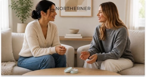 two women sitting and talking, with a nicotine pouch can on the table