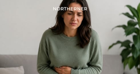 Woman holds her stomach, feeling queasy